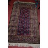 A Persian woollen blue ground Bokhara rug, the trailing central ground within multiple tramline