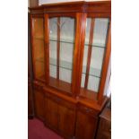 A reproduction yew wood breakfront display cabinet, having glazed upper doors, width 112cm