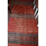 A Persian woollen red ground Bokhara rug, having multiple tramline borders, 315 x 230cm