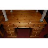 A modern pine twin pedestal writing desk, having an arrangement of nine drawers with turned knob