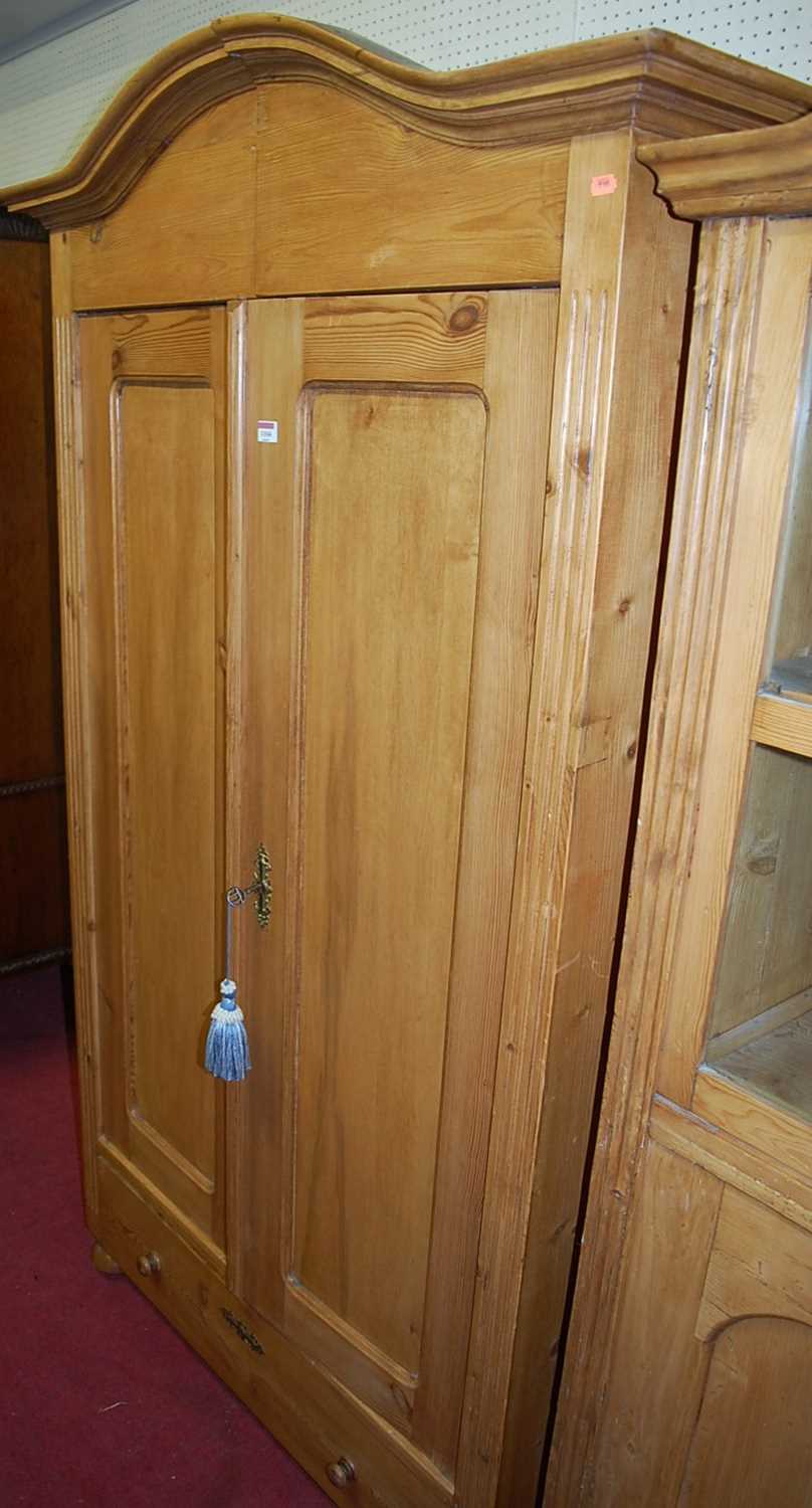 A French pine double door armoire, having single long lower drawer on bun supports (comprised of two