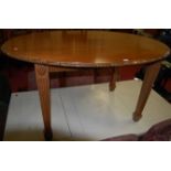 An Adam style oval mahogany dining table, having acanthus leaf carved edge and raised on square