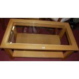 A contemporary light oak and clear glass inset two-tier coffee table, length 99cm