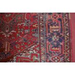 A Caucasian red ground woollen rug, having all-over geometric floral decorated field (with heavy