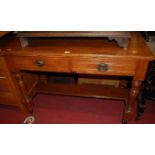 An Edwardian stained oak two drawer side table, raised on ring turned and square cut supports, w.
