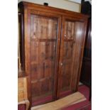 A large early 20th century double door glazed bookcase, with adjustable shelves (lacking