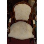 An early 20th century French stained beech and cream floral silk damask upholstered fauteuil, in the