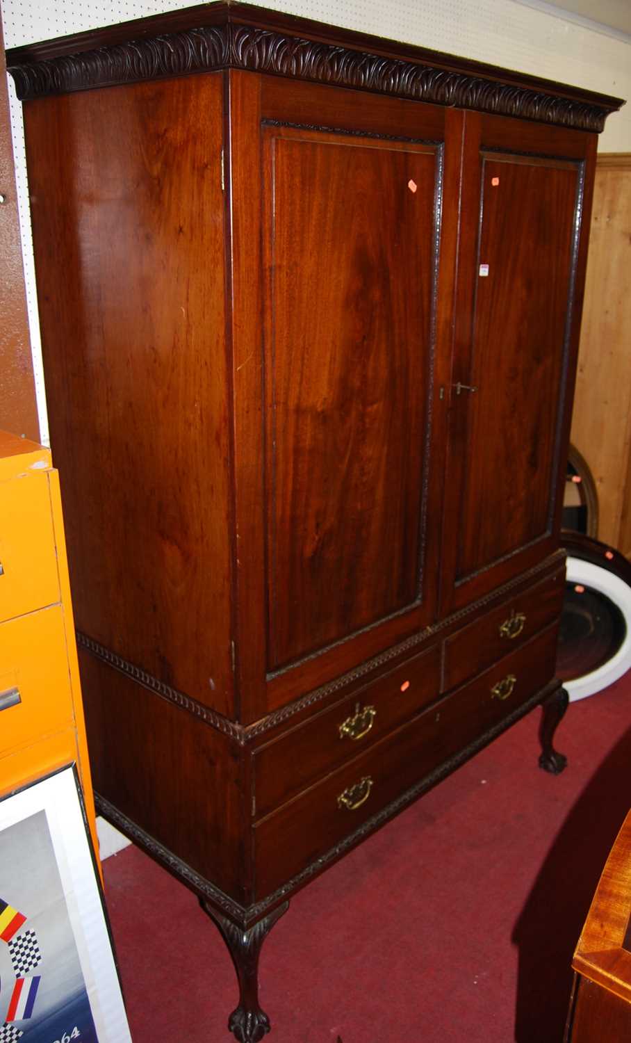 A circa 1900 Chippendale style mahogany cupboard on stand, the twin recessed panelled upper doors