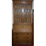 An early 20th century oak bureau bookcase, having twin lead glazed upper doors, w.92cm