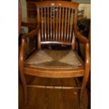 A circa 1900 walnut slatback elbow chair, having inset rush seat, w.54cm