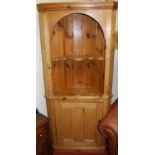 A reclaimed pine barrel back free standing corner cupboard, having a panelled lower cupboard door,