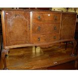 A 1930s figured walnut ledgeback serpentine front sideboard, having three central drawers flanked by