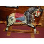 A Collinson mid-20th century childs dapple grey rocking horse, raised on a stained beech stand,