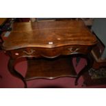 An early 19th century provincial French walnut serpentine front single drawer two-tier hall table,