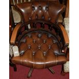 A reproduciton mahogany framed tan leather buttoned and studded tub swivel desk chair, w.60cm