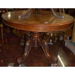 A mid-Victorian figured walnut oval tilt-top pedestal breakfast table, raised on relief carved