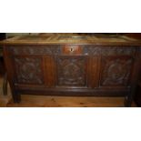 An 18th century provincial carved and joined oak three panelled hinge topped coffer, having floral