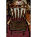 A stained hardwood and fruit decorated slatback rocking armchair, w.65cm