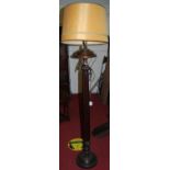 A mahogany reeded pedestal standard lamp with shade