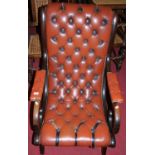 A reproduction mahogany tan leather buttoned and further studded X-frame open arm chair, width 64cm