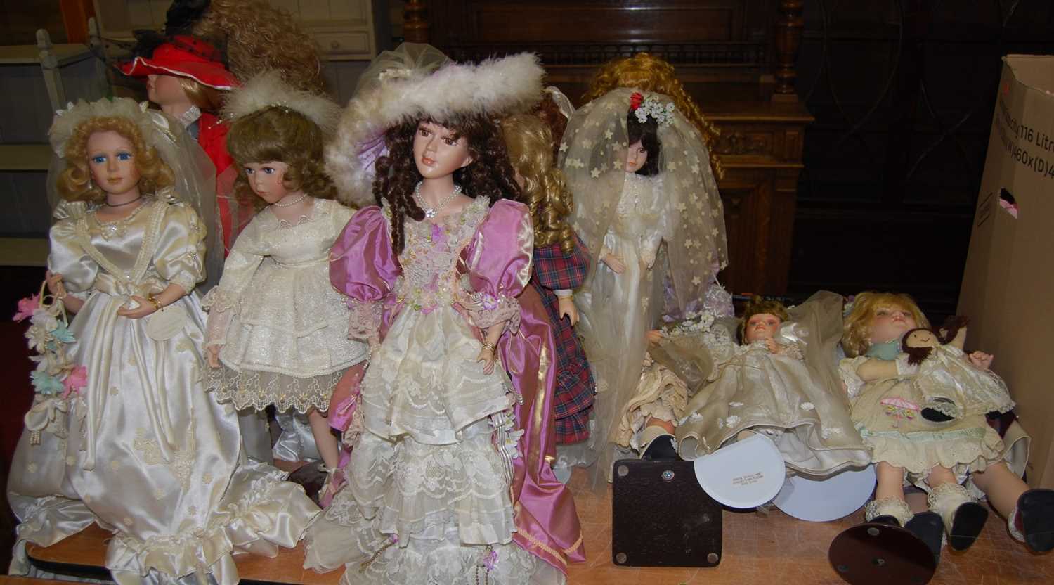A collection of modern porcelain standing dolls, all in full dress, some being from the