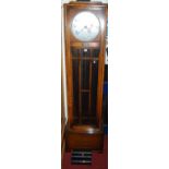 A 1930s oak longcase clock, the silvered dial signed Enfield Made in England, with glazed trunk door