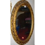 A contemporary gilt gesso floral decorated oval wall mirror, 61 x 49cm