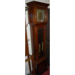 An Edwardian mahogany grandmother clock, the silvered dial within pierced spandrels, having triple