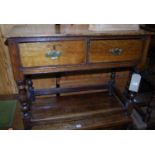 An antique oak round cornered two-drawer side table, raised on turned supports to square lower outer