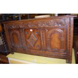 An early 20th century relief carved and joined oak three panelled hinge top coffer, width