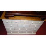 A modern pine and part white painted side chest, fitted with thirteen various sized drawers with