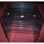 A good contemporary heavy clear glass nest of three occasional tables, each of curved form, the