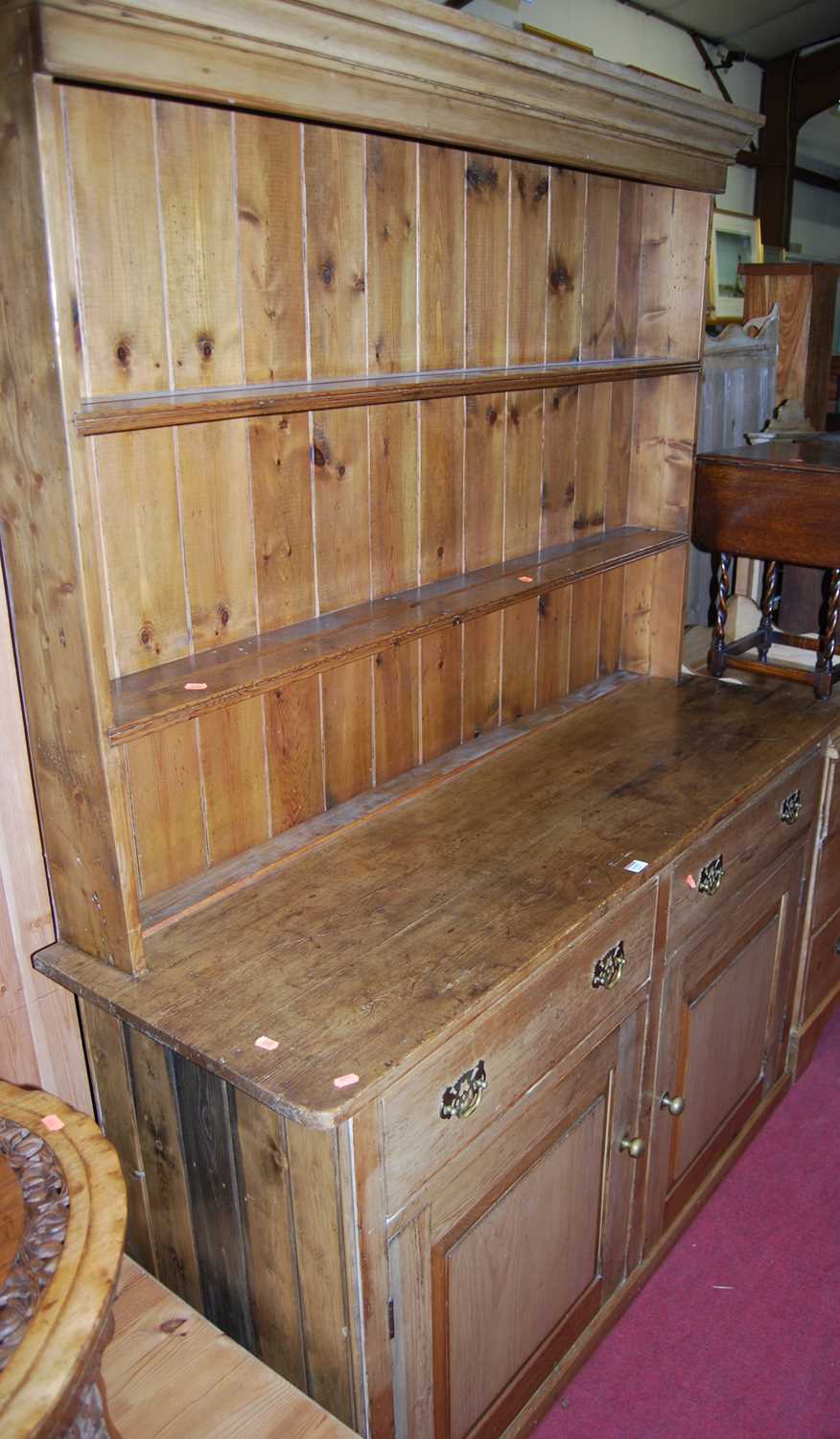 A Victorian pine round cornered kitchen dresser, the two-tier open plate-rack over base fitted