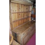 A Victorian pine round cornered kitchen dresser, the two-tier open plate-rack over base fitted