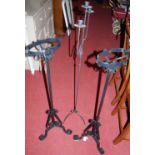 A pair of early 20th century black painted wrought iron paraffin lamp stands (lacking fittings);