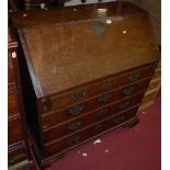 A George III mahogany slopefront writing bureau, having a fitted interior, over four long