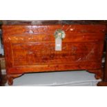 An Eastern relief carved and stained camphorwood hinge top blanket box, width 100cm