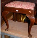 A late Georgian walnut dressing stool, having a red floral fabric drop-in padseat, and raised on