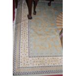 A Persian style machine woven cream ground rug, with central floral medallion within trailing