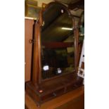 A Queen Anne style mahogany swing dressing mirror, the arched and bevelled mirror plate within