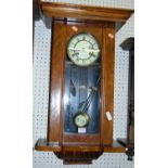 An early 20th century figured walnut Vienna droptrunk wall clock, with pendulum