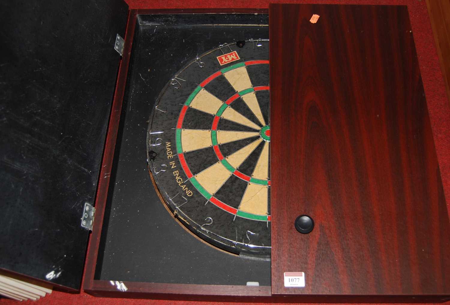 An M.Y. dartboard in faux mahogany wall cabinet