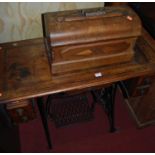 A late Victorian Serata walnut and cast iron treadle sewing table