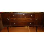 A 1970s Schreiber Furniture polished teak low small sideboard, having three long central drawers,