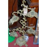 A contemproary decorative painted and pierced metal candle-stand, with four hanging fish from scroll