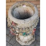 A reconstituted stone floral decorated pedestal garden urn, h.64cm