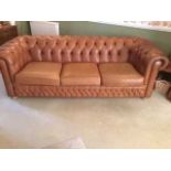 A good contemporary tan leather and brass studded three seater button back Chesterfield, width