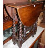 An early 20th century oak dropflap occasional table, raised on barleytwist and square cut supports