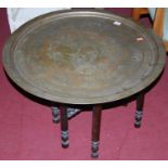 An early 20th century circular engraved brass topped folding Benares table, dia. 69cm