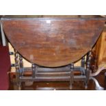 An antique oak drop leaf table, raised on spiral turned supports with gate leg action